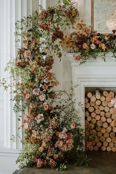 the fireplace is decorated with flowers and greenery