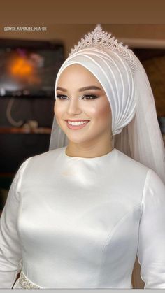 a woman wearing a white veil and dress