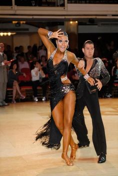 two people dancing on a dance floor in front of an audience