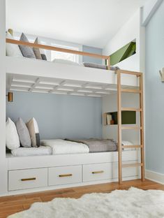 a bunk bed with white drawers underneath it