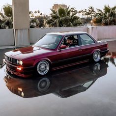 a maroon car is parked in the water