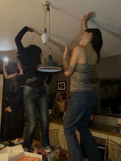 two women are dancing in the middle of a room