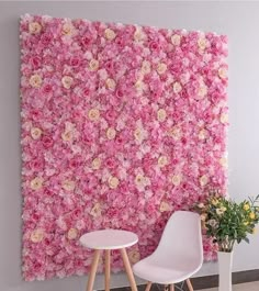 a pink flowered wall in the corner of a room with two chairs and a table