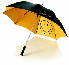 a yellow and black umbrella with a smiley face drawn on the side, in front of a white background