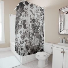 a bathroom with a toilet, sink and shower curtain in it's center area