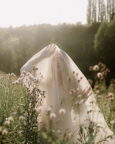 a woman in a white dress standing in a field