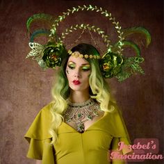 Artemisia - Green fairy absinthe inspired headdress comprised of two large halos hovering above lined with green leaves in alternating directions, adorned with deep green stones, and accented with twinkling lights with an additional draping golden chain with green stones and a forehead chain with the tiniest green stone pollen finished off with two large chartreuse velvet and metallic flowers, glittering green faerie wings, and soft peacock sword feathers. The perfect look to take flight after your first sip of absinthe! Halo Lights, Chartreuse Velvet, Green Fairy Absinthe, Absinthe Fairy, Faerie Wings, Forehead Chain, Metallic Flowers, Headpiece Art, Fairy Headpiece