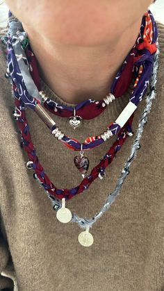 a close up of a person wearing multiple necklaces