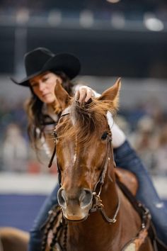 a woman riding on the back of a brown horse