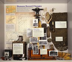 there are many things on display in this museum case, including an old camera and other items