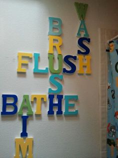 the bathroom wall is decorated with colorful letters