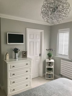 a bedroom with white furniture and gray walls