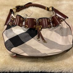 This Bag Is Very Unique In Its Style . It Has The Classic Burberry Pattern Along With Touches Of Beautiful Golden Hardware And Leather That Gives A Nod To A Bit Of Equestrian . Designer Pouch Shoulder Bag With Leather Handles, Designer Pouch Hobo Bag For Errands, Designer Hobo Pouch Bag For Errands, Designer Hobo Bag With Detachable Strap For Errands, Designer Satchel Hobo Bag, Designer Pouch Hobo Bag, Designer Hobo Bag With Branded Hardware For Everyday, Designer Shoulder Bag With Branded Hardware For Errands, Burberry Pattern