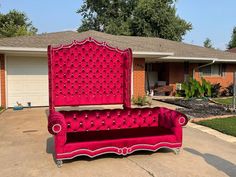 a pink couch sitting in front of a house