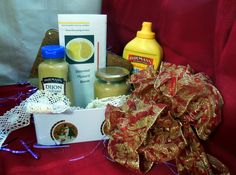 an assortment of condiments in a gift box on a red cloth covered table