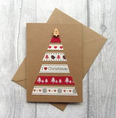 a card with a christmas tree on it sitting on top of a piece of brown paper