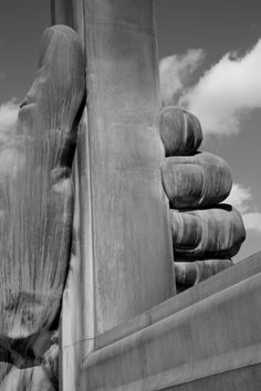 a black and white photo of a large statue with hands on it's sides