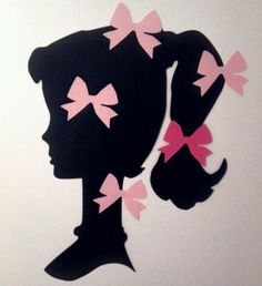 the silhouette of a woman with pink bows on her hair is shown against a white wall