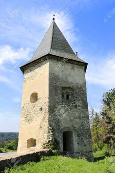 an old stone tower with a steeple on top in the middle of a field