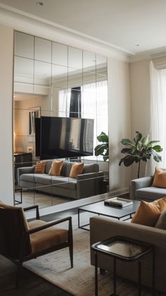 a living room with couches, chairs and a large mirror on the wall in front of it