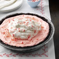 a pie with whipped cream and peppermint on top is sitting on a table