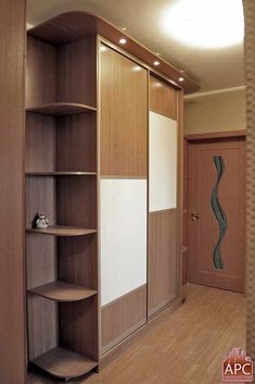 an empty room with wooden floors and shelving unit in the corner, next to a door