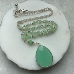 "A green natural stone Oval shaped pendant, in a Rhodium plated setting, suspended on a Rosary beading and silver plated chain, this necklace is great for day or evening wear. MATERIAL Silver Plated Chain - Nickle Free   Green rosary chain Green natural stone Pendant MEASUREMENTS Overall length incl chain extn 24\"/61cms Pendant length - 1.25\"/3cms PRESENTATION The Necklace will be attached to Giftcard, Giftwrapped in Tissue and tied with Ribbon, presented in a Organza Pouch - Perfect if you are sending direct as a Gift - I can also enclose a Message on your behalf, just message me the details. DELIVERY All Purchases are despatched 1st Class, Signed U.K Delivery - Tracked Worldwide with Royal Mail, to ensure a quick delivery. ESTIMATED DELIVERY TIMES U.K - 1 - 3 Days USA - CANADA - 5 - 10 Green Jade Jewelry With Adjustable Chain, Jade Pendant Necklaces For Crafting, Green Jade Pendant Crystal Necklace, Green Spiritual Beaded Chain Jewelry, Green Spiritual Jewelry With Beaded Chain, Spiritual Green Jewelry With Beaded Chain, Green Jewelry With Round Beads And Adjustable Chain, Green Jewelry With Adjustable Chain And Round Beads, Silver Jade Gemstone Crystal Necklace