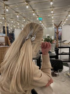 a woman with long blonde hair sitting at a table