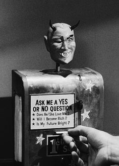 a person is holding up a sign with a devil head on it and an old fashioned phone in front of them