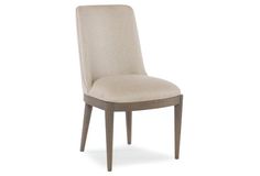 an upholstered dining chair with a wooden frame and backrest, in beige fabric