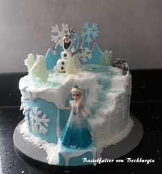 there is a cake that has frosting on it and snowmen in the background