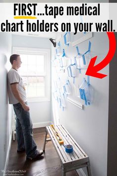 a man standing next to a wall with tape on it