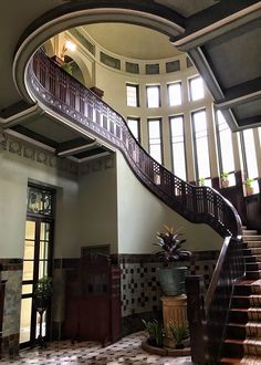 a staircase leading up to the second floor in a large room with tiled floors and walls