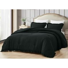 a bed with black comforter and pillows in a room