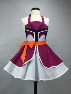 a dress with an orange ribbon around the waist and purple, white, and black design on it