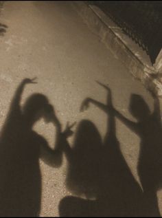 two people holding their hands up in the air while standing next to a skateboard