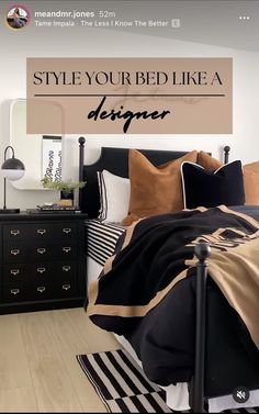 a bedroom with black and white striped bedspread, gold throw pillows, and an oversized sign that says style your bed like a designer