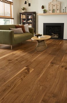 a living room filled with furniture and a fire place next to a fireplace on top of a hard wood floor