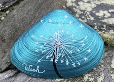 a blue rock with a dandelion painted on it