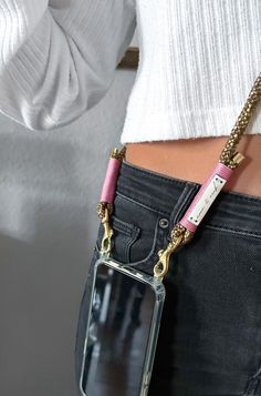 a person wearing jeans and holding a cell phone in their pocket with a chain attached to it