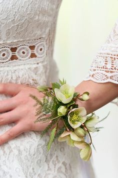 a close up of a person wearing a wedding dress and holding a bouquet of flowers