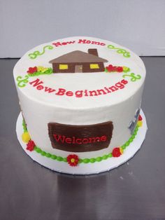 a white cake with the words new beginnings on it and a welcome home sign painted on top