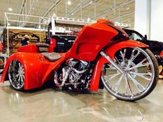 an orange motorcycle parked in a garage next to other vehicles