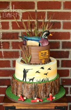 a three tiered cake decorated with birds and trees