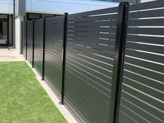 a large black fence next to a building