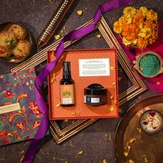 an assortment of items displayed on a table with purple ribbon and decorative objects around it