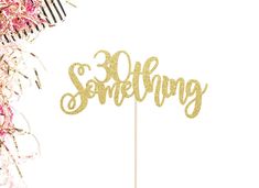 there is a cake topper that says something in gold glitter letters on a stick