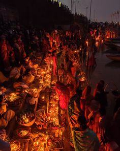 many people are sitting around with candles on the ground