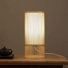 a lamp that is sitting on top of a table next to a teapot and cup