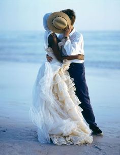 a man and woman hugging on the beach